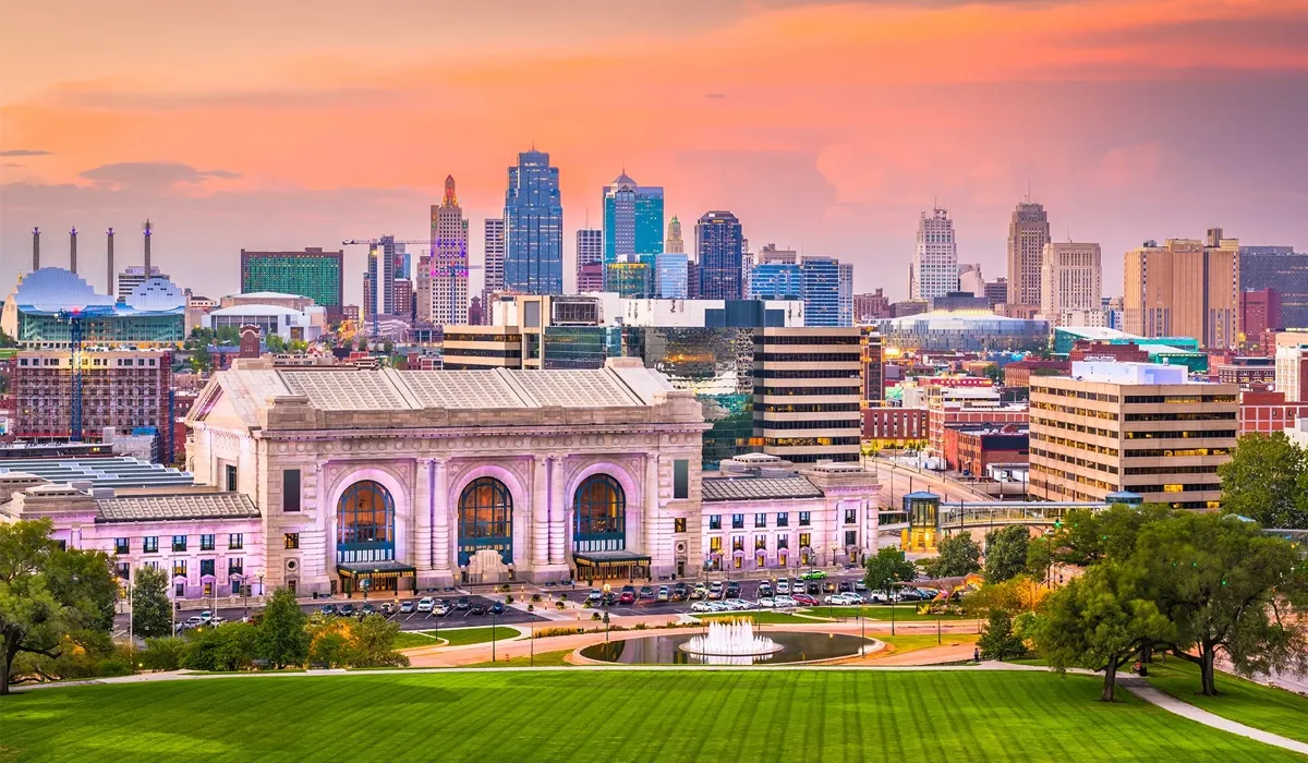 A panoramic view showcases the Kansas City Union Station grand facade overlooking a lush green lawn and a circular fountain